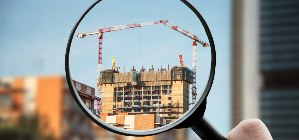 A hand is holding a magnifying glass up to the location of a construction worksite with two cranes, looking for what ASR might be.