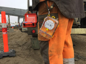 A Maturix Sensor is hanging off the pants of a construction worker.