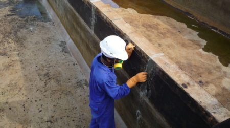 A construction worker is repairing concrete leaks.
