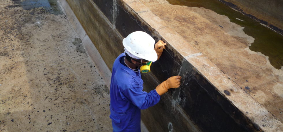 A construction worker is repairing concrete leaks.