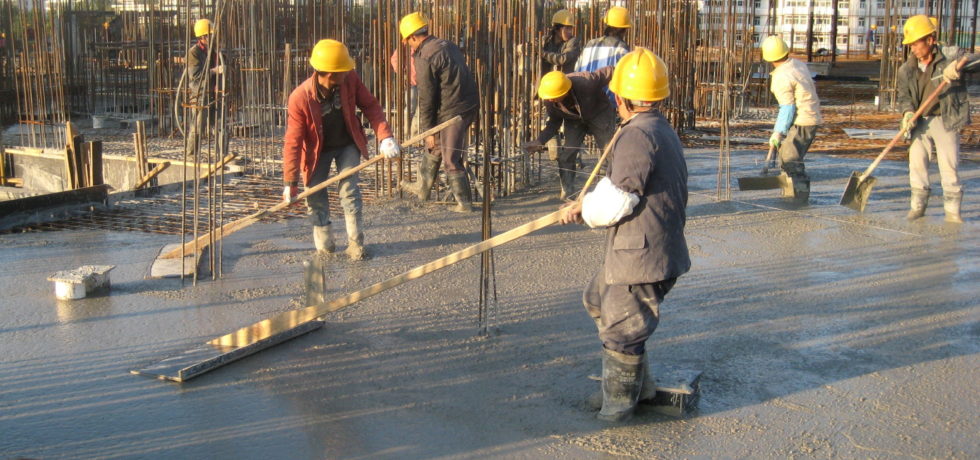 Several Chinese construction workers are concreting.