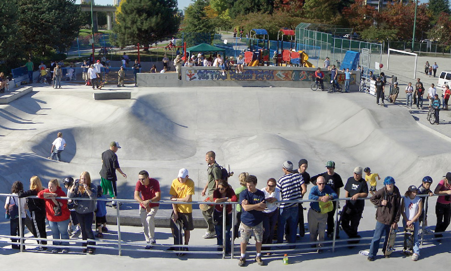 A crowd surrounds a skateboarding zone.