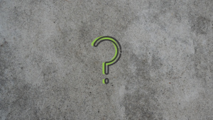 A question mark highlighted in green is in front of a concrete background.