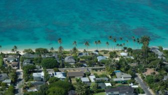 A vast ocean sits before numerous homes on a Hawaiian island that have had floodproofing.