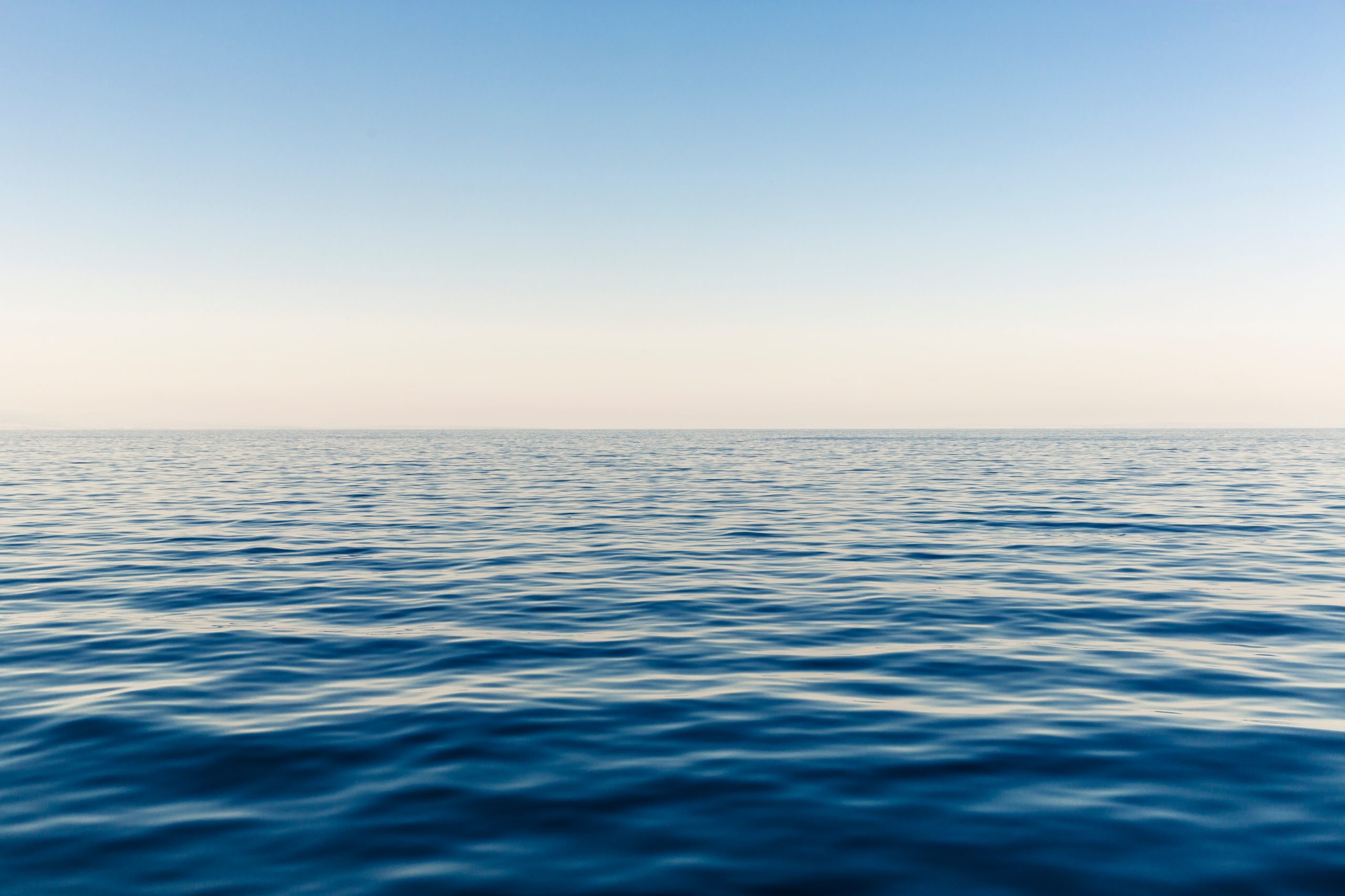 An expanse of water can be seen stretching straight all the way back to the horizon.