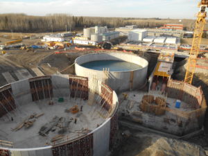 Two tanks belonging to Aquatera's water plant stand side by side near partially constructed structures.