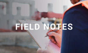 The title "Field Notes" is in the foreground while an image of a construction worker holding a note pad is in the background.