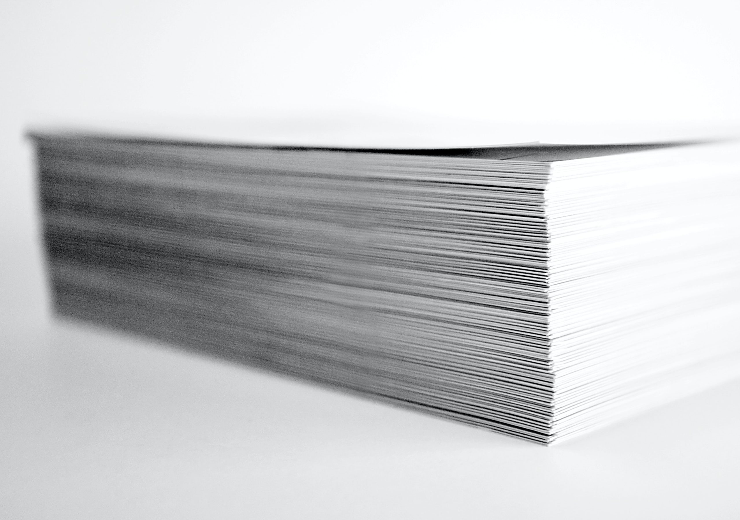 A pile of ACI papers are neatly organzed into one column against a white background.